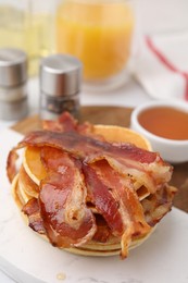 Photo of Delicious pancakes with bacon and honey on table, closeup