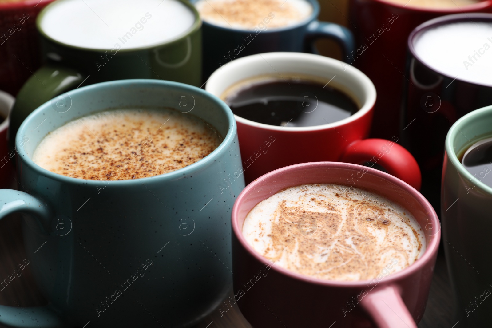 Photo of Many different cups with aromatic hot coffee on table, closeup