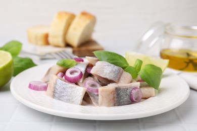 Photo of Plate with tasty marinated fish, onion and basil on light tiled table, closeup