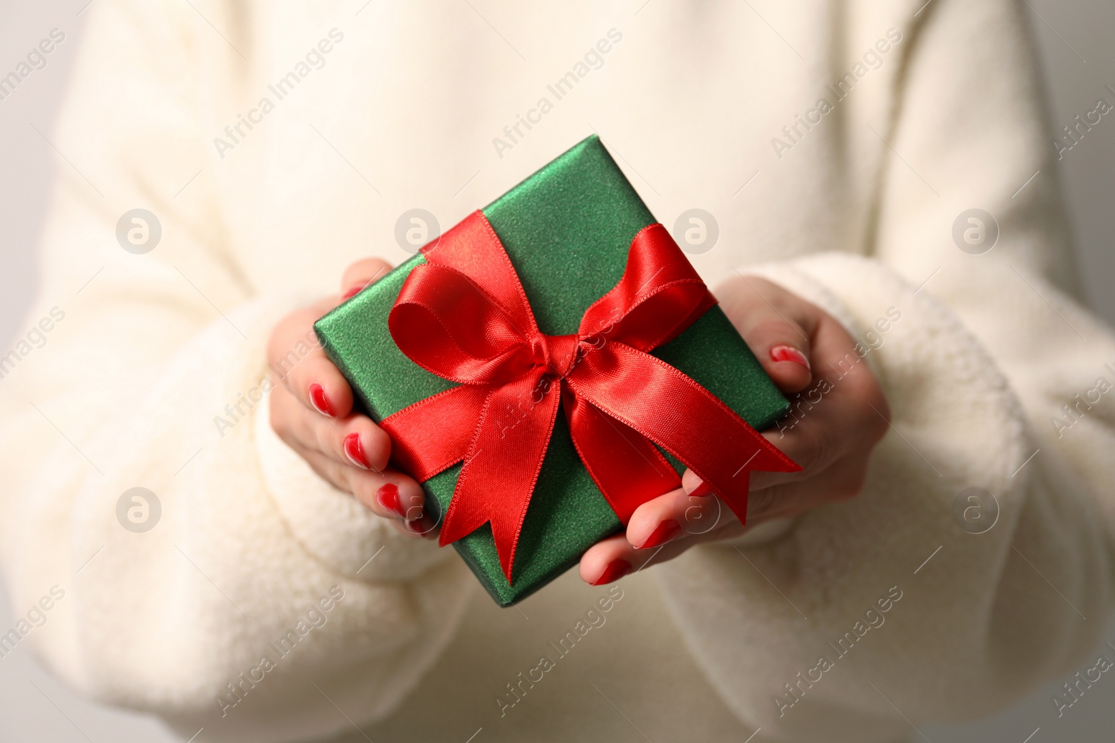 Photo of Christmas present. Woman holding gift box, closeup