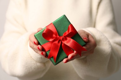 Photo of Christmas present. Woman holding gift box, closeup