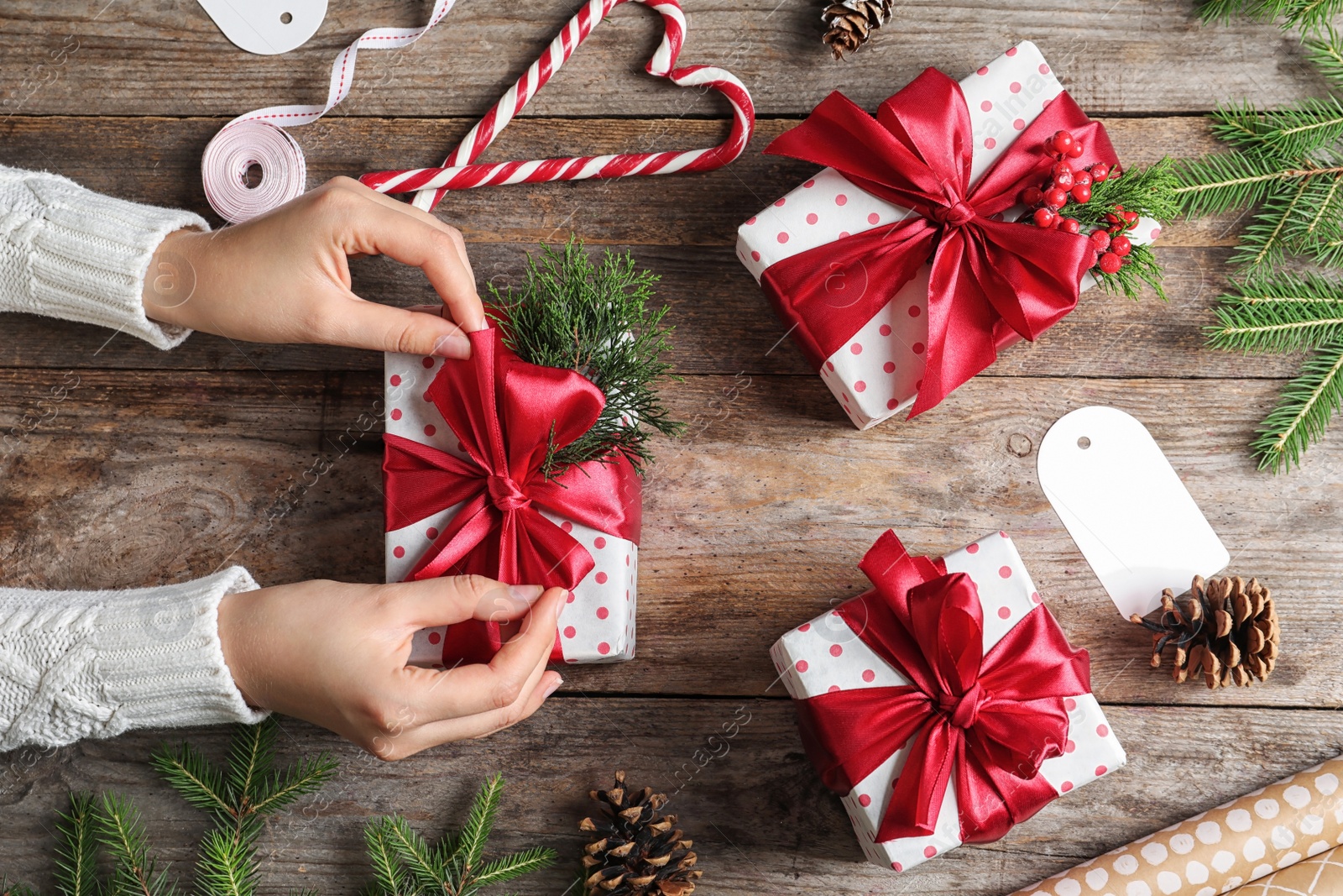 Photo of Woman wrapping Christmas gift at wooden table, top view