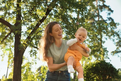 Photo of Beautiful mother with her cute daughter spending time together in park on summer day