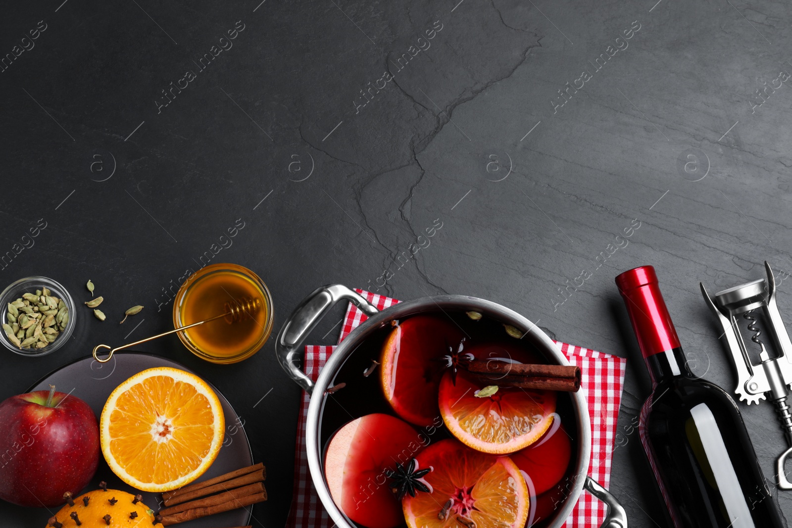 Photo of Delicious mulled wine and ingredients on grey table, flat lay. Space for text