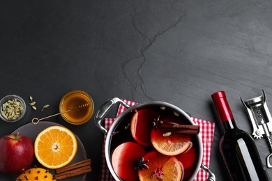 Delicious mulled wine and ingredients on grey table, flat lay. Space for text