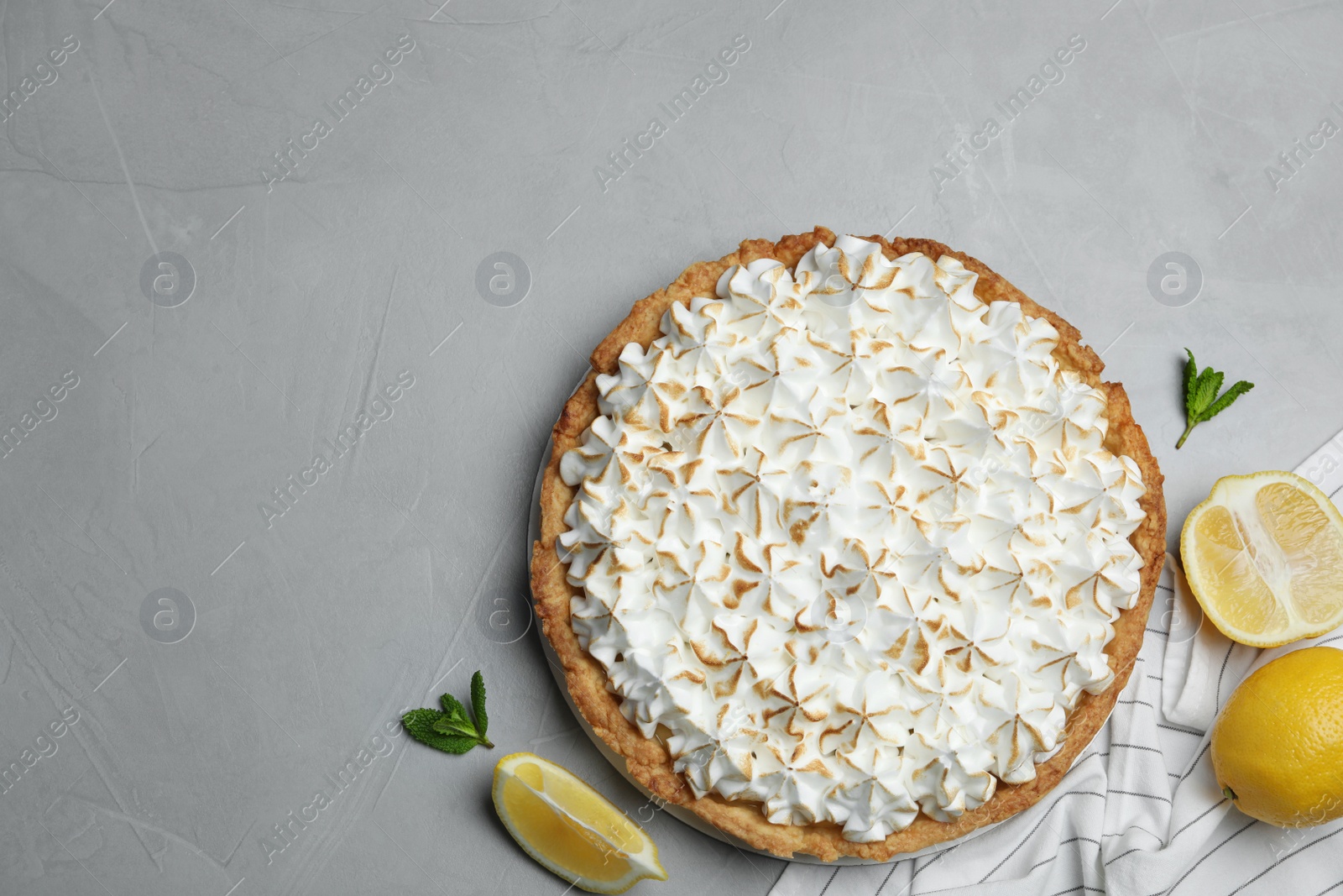 Photo of Flat lay composition with delicious lemon meringue pie on grey table