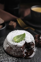 Photo of Delicious fresh fondant with hot chocolate and mint on slate plate, closeup
