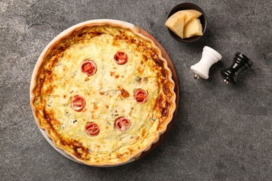 Photo of Delicious homemade cheese quiche and spices on gray table, flat lay