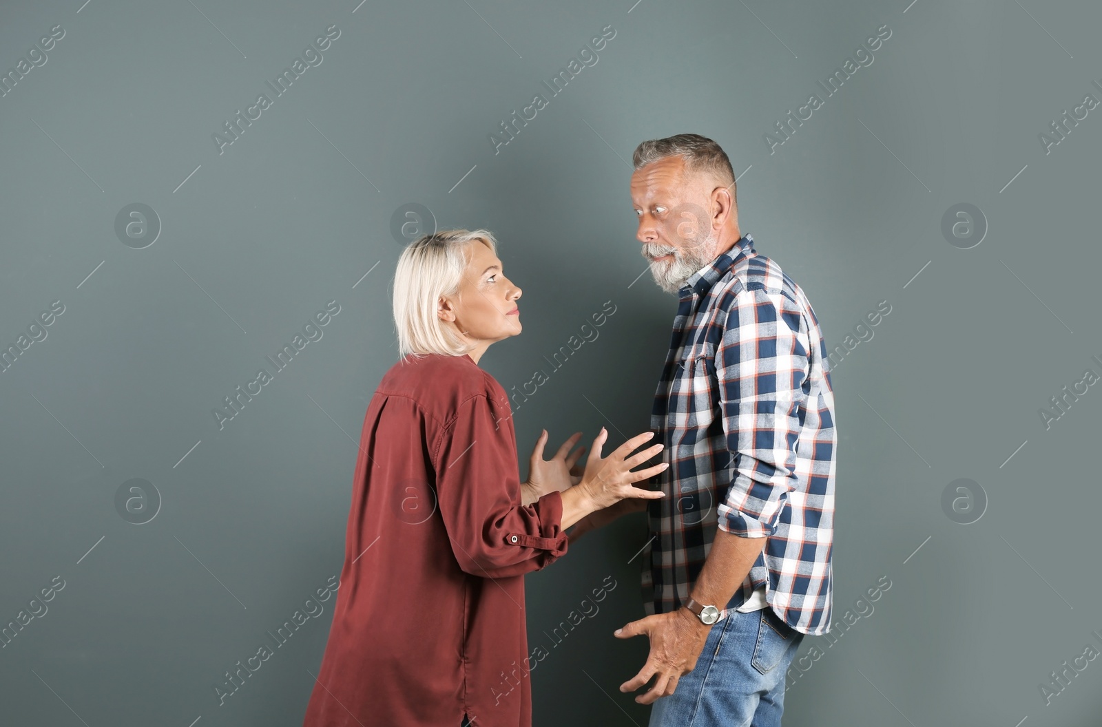 Photo of Mature couple having argument on color background. Relationship problems