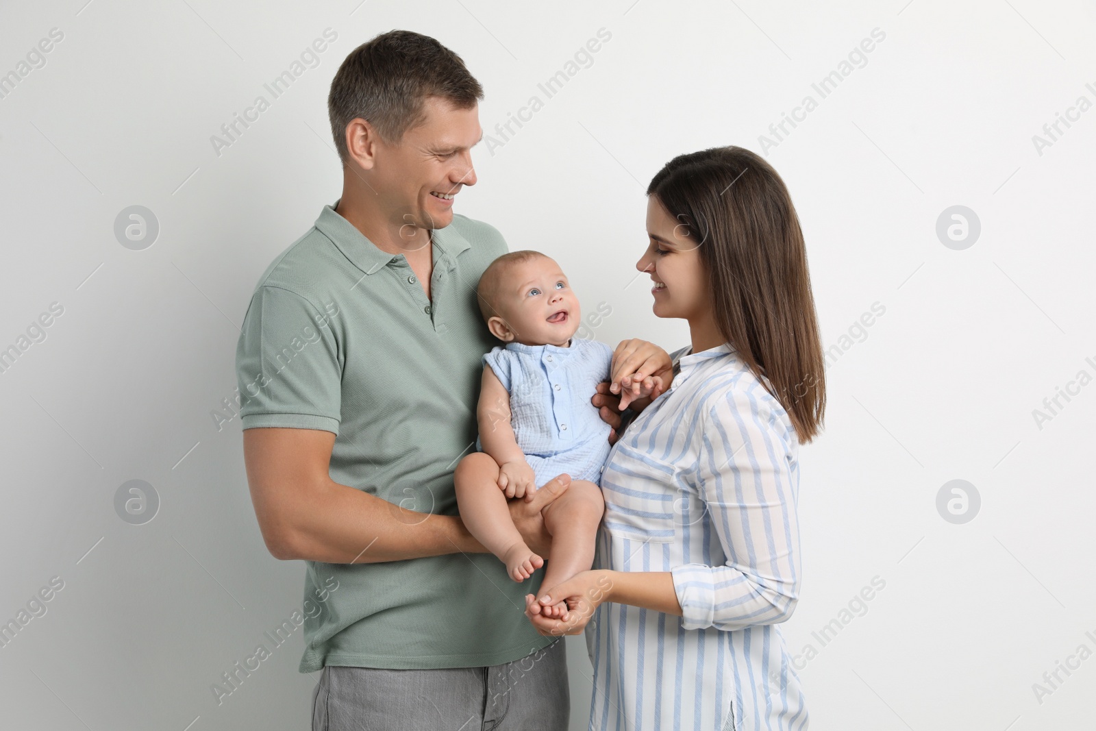 Photo of Portrait of happy family with their cute baby on white background