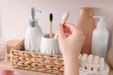 Bath accessories. Woman organizing personal care products indoors, closeup