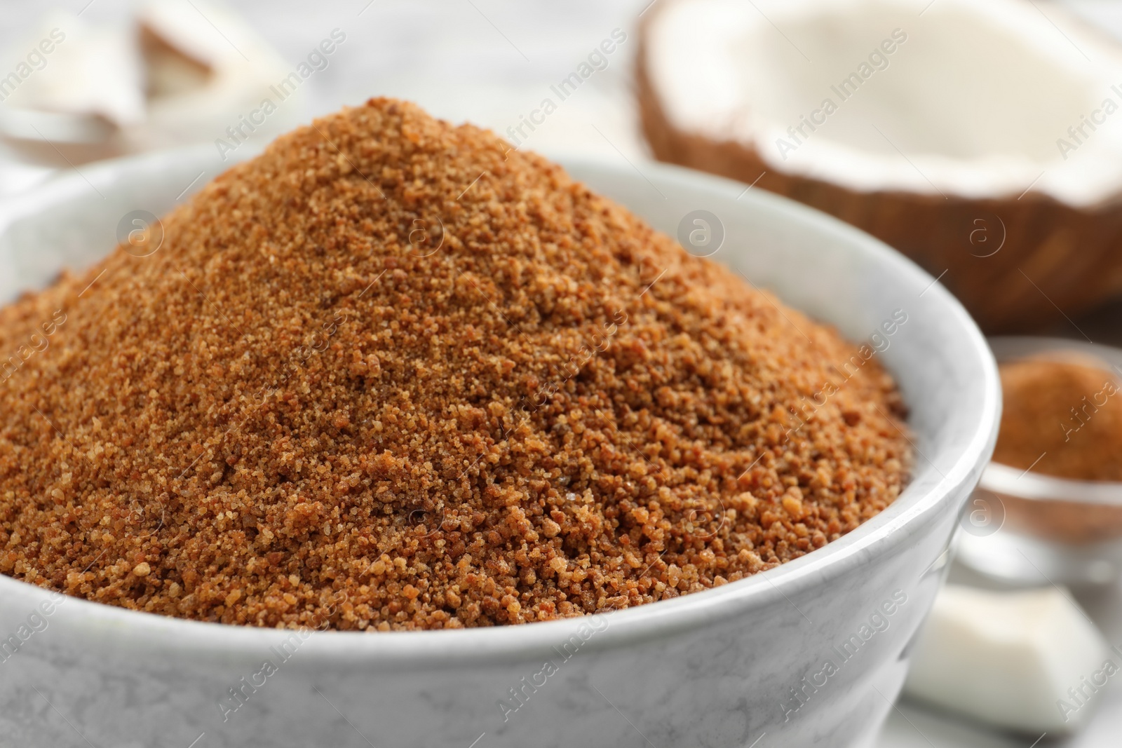 Photo of Natural coconut sugar in ceramic bowl, closeup