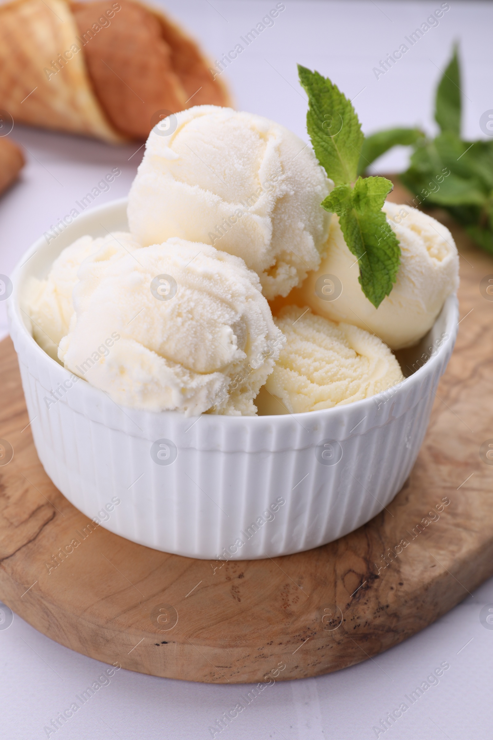 Photo of Bowl of ice cream and mint leaves on white table