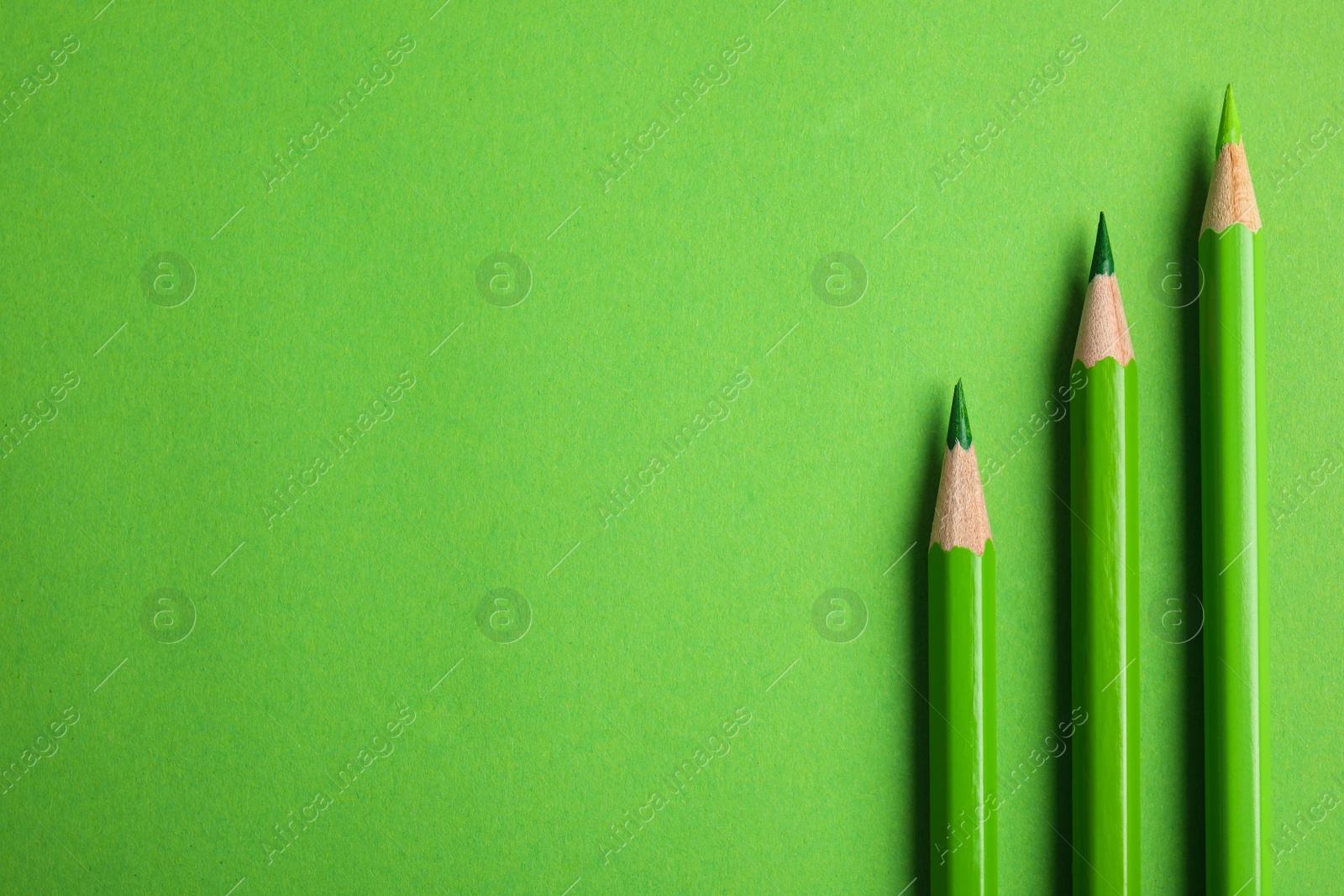 Photo of Flat lay composition with color pencils on green background. Space for text