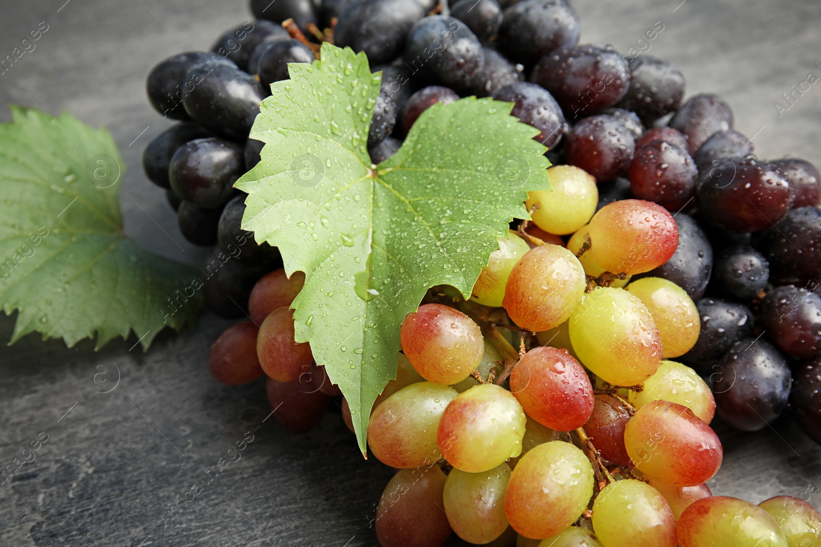 Photo of Different fresh ripe juicy grapes on table, closeup