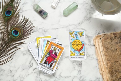 Flat lay composition with Emperor, Wheel of Fortune and other tarot cards on white marble table