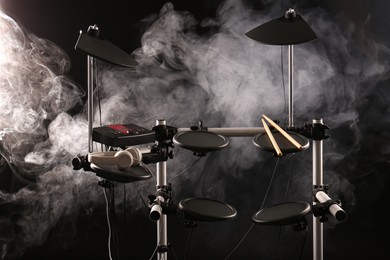 Photo of Modern electronic drum kit and smoke on dark background. Musical instrument