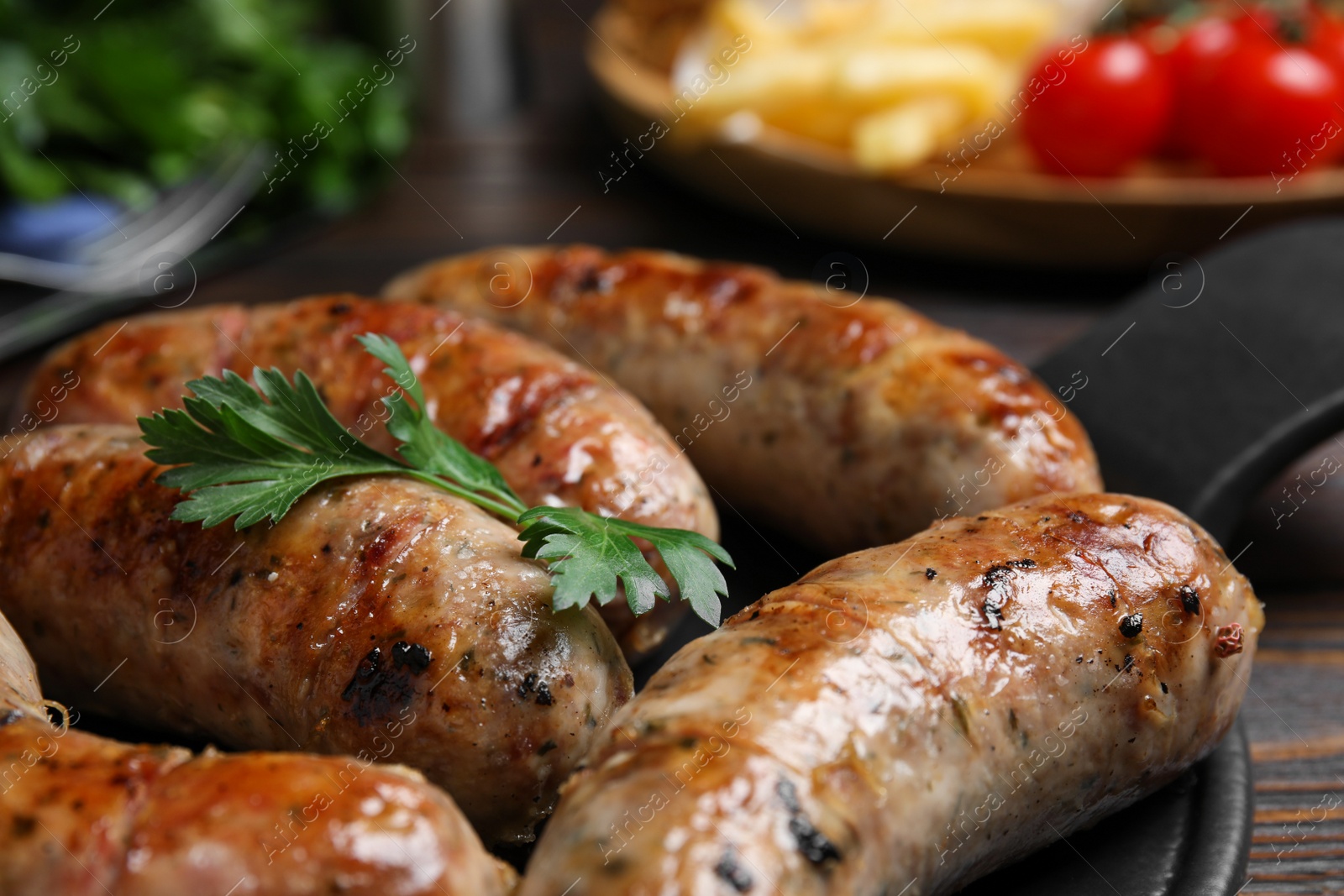 Photo of Delicious grilled sausages with parsley on table, closeup