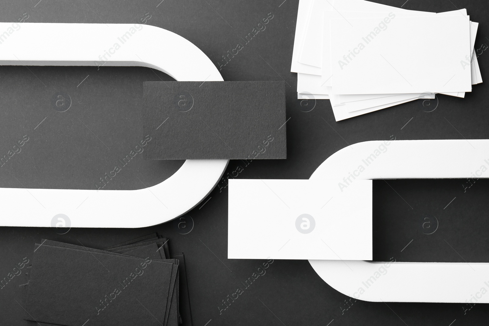 Photo of Stylish presentation of blank business cards on black background, flat lay. Mockup for design