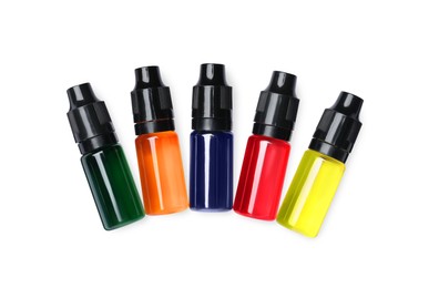 Bottles with different food coloring on white background, top view