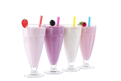 Photo of Different fresh tasty milk shakes in glasses with ingredients on white background
