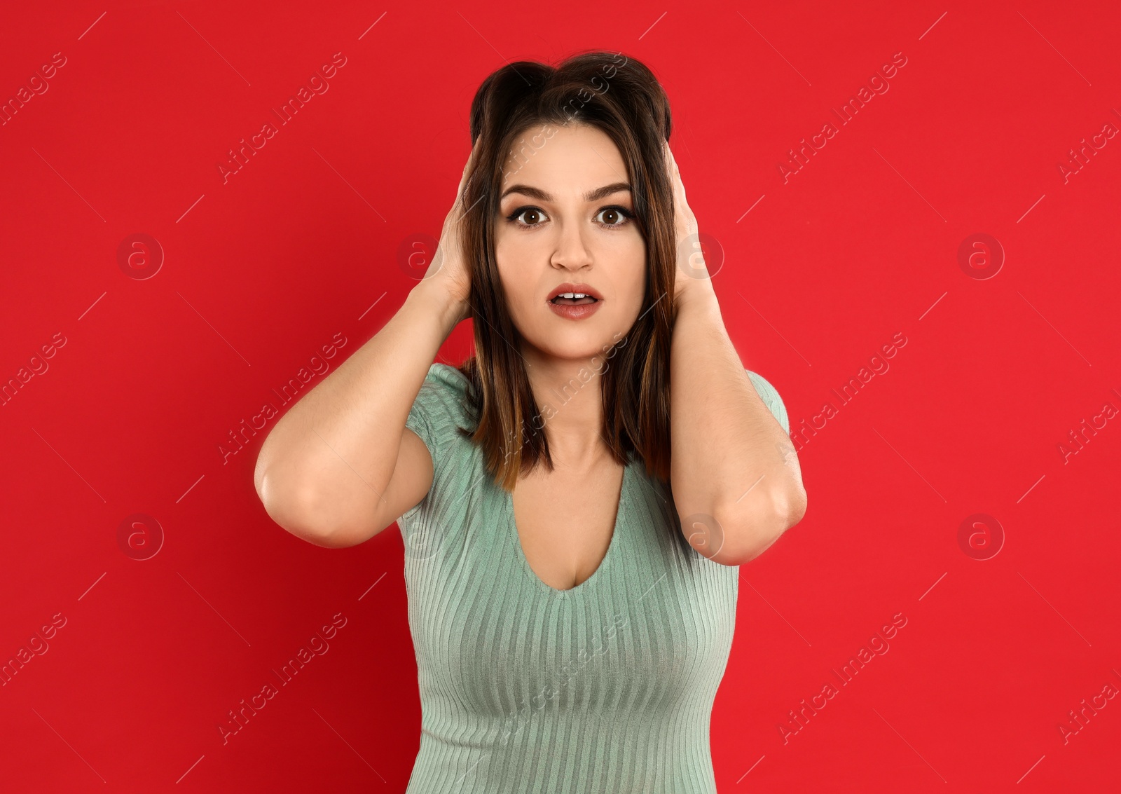 Photo of Beautiful young woman posing on red background
