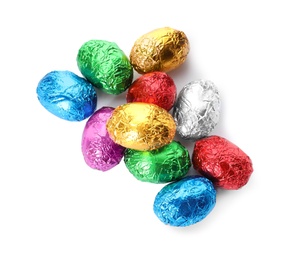 Chocolate eggs wrapped in colorful foil on white background, top view