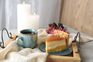 Photo of Cup of tea and delicious cheesecake on grey table