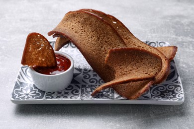 Photo of Plate with crispy rusks and dip sauce on light table