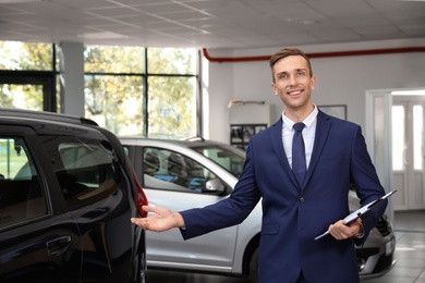 Portrait of young car salesman in dealership