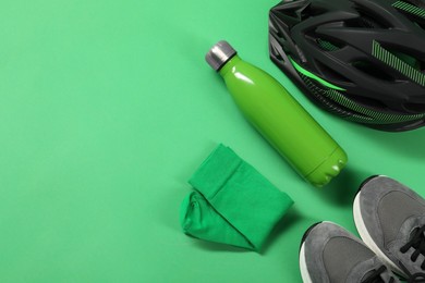 Different sports equipment on green background, flat lay. Space for text