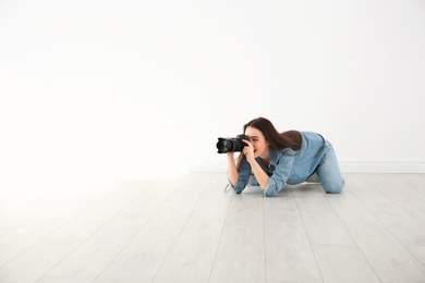 Female photographer with camera lying on floor indoors