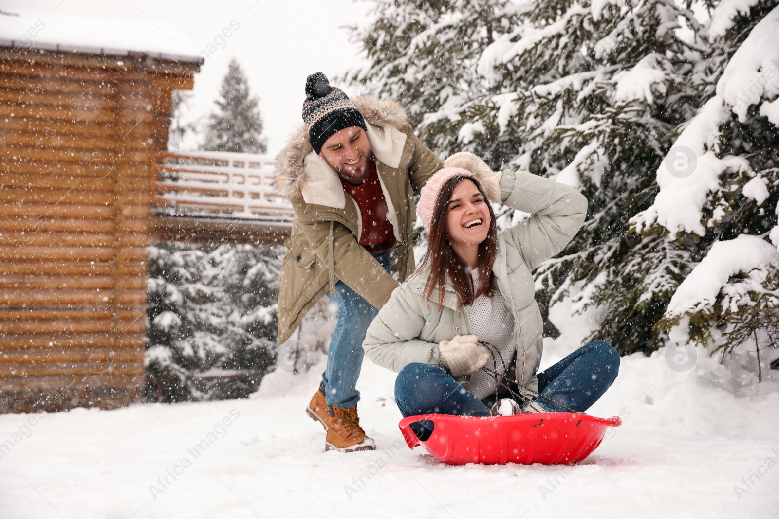 Photo of Couple having fun and sledding on snow. Winter vacation