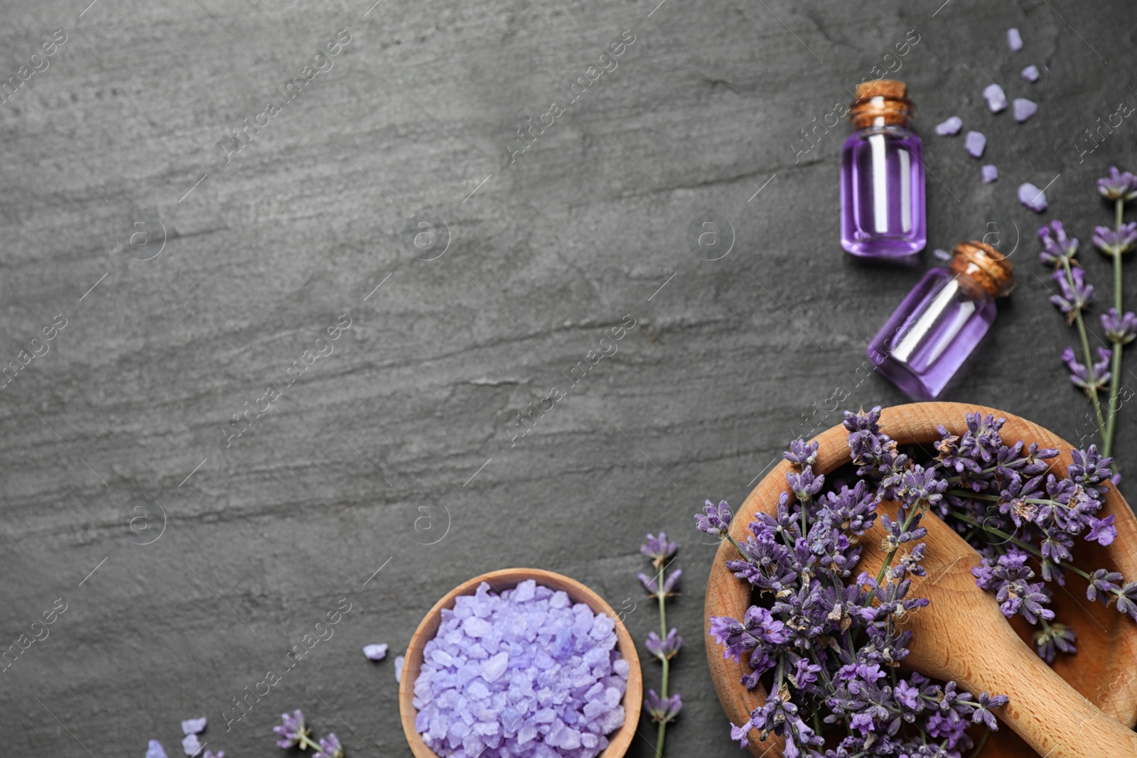 Photo of Cosmetic products and lavender flowers on dark grey background, flat lay. Space for text