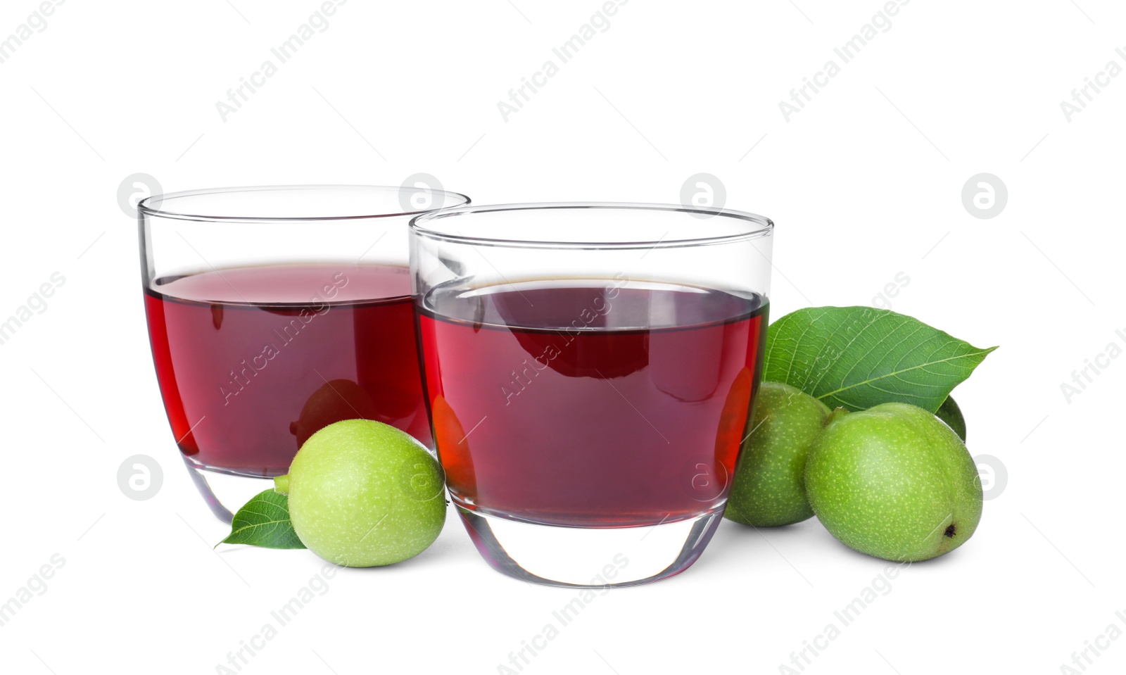 Photo of Delicious liqueur and green walnuts on white background