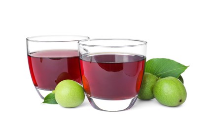 Photo of Delicious liqueur and green walnuts on white background