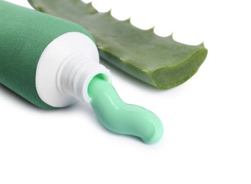 Open tube of toothpaste and aloe vera leaf on white background