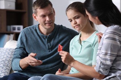 Photo of Parents talking with their teenage daughter about contraception at home. Sex education concept
