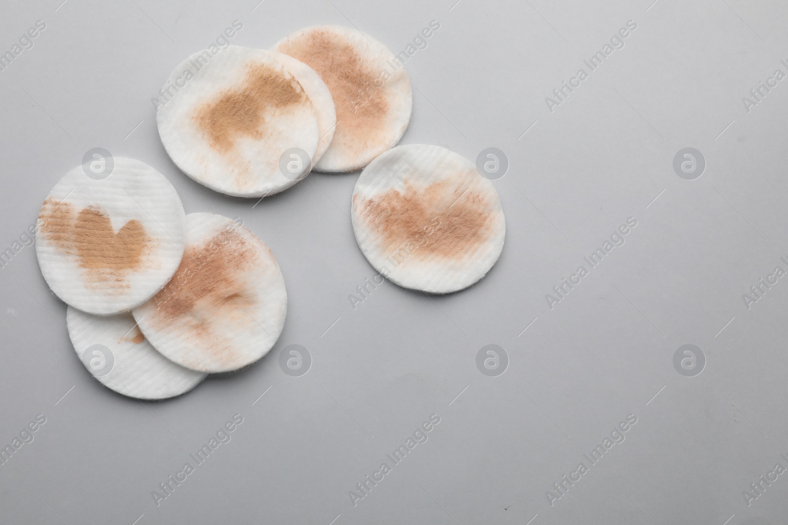 Photo of Dirty cotton pads after removing makeup on light grey background, flat lay. Space for text