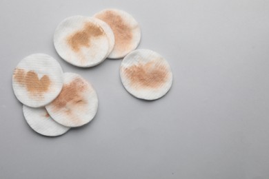 Photo of Dirty cotton pads after removing makeup on light grey background, flat lay. Space for text