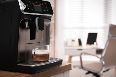 Photo of Modern espresso machine pouring coffee into cup in office. Space for text