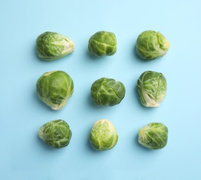Fresh Brussels sprouts on light blue background, flat lay