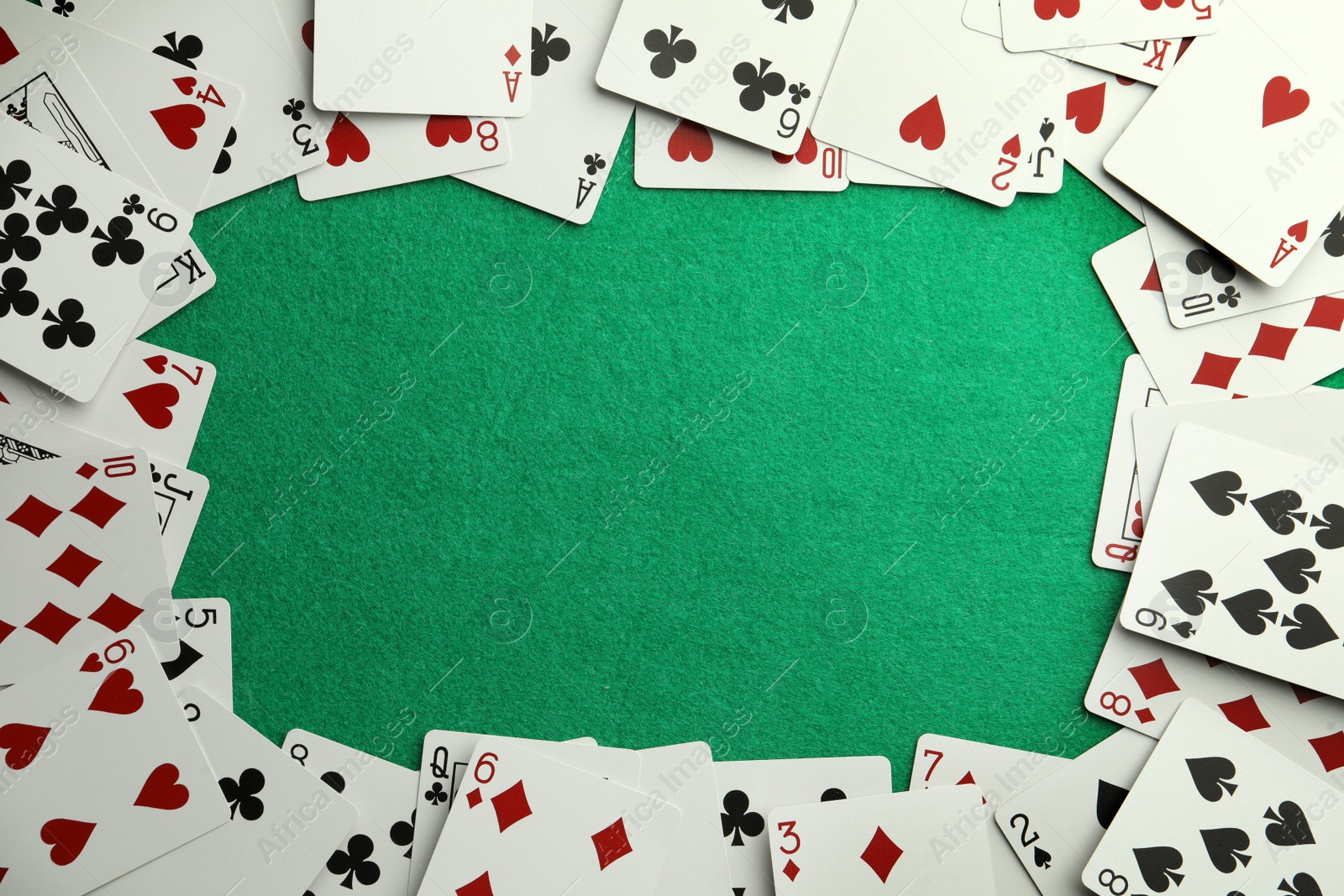 Photo of Frame made of playing cards on green table, top view. Space for text
