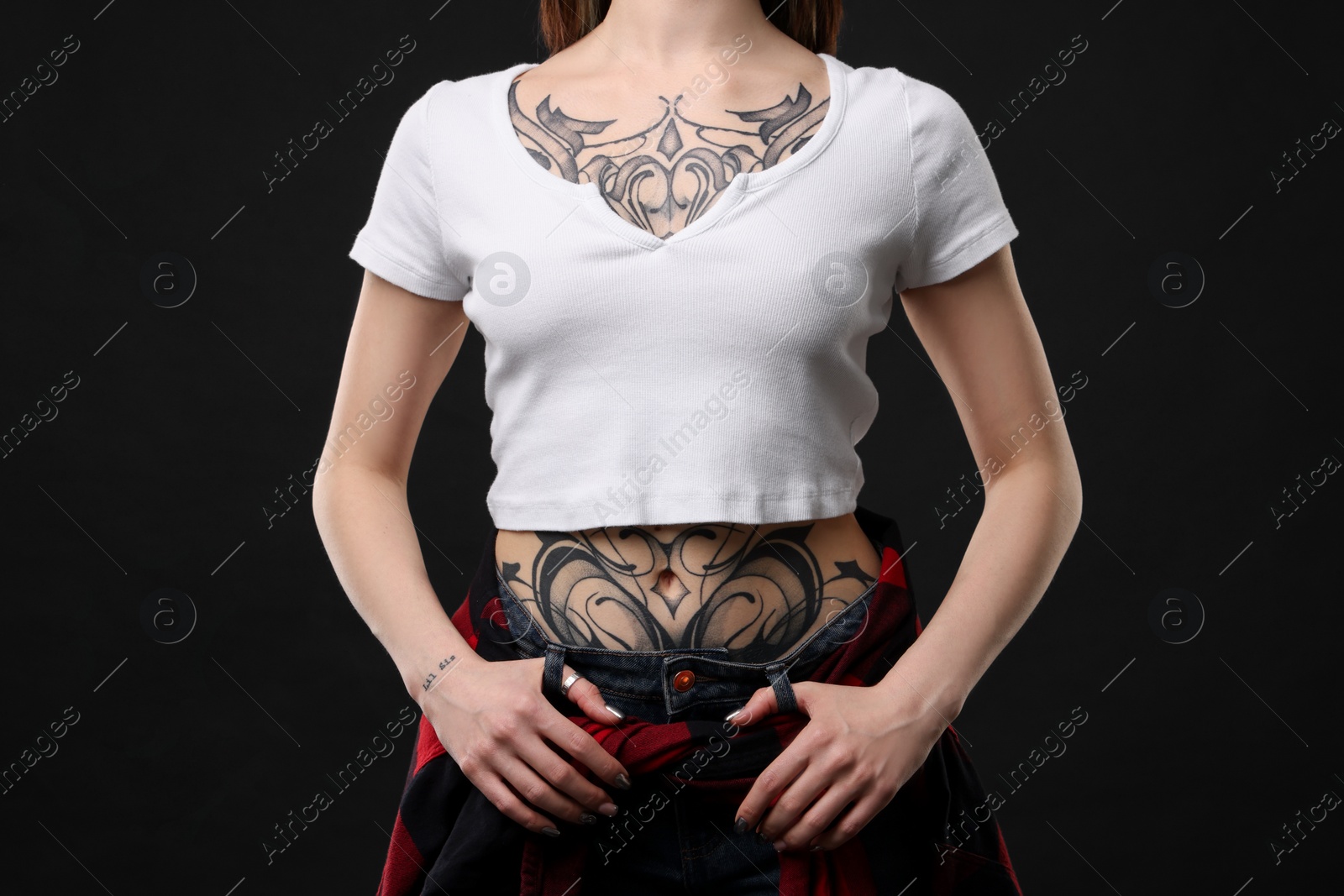 Photo of Woman with cool tattoos on black background, closeup