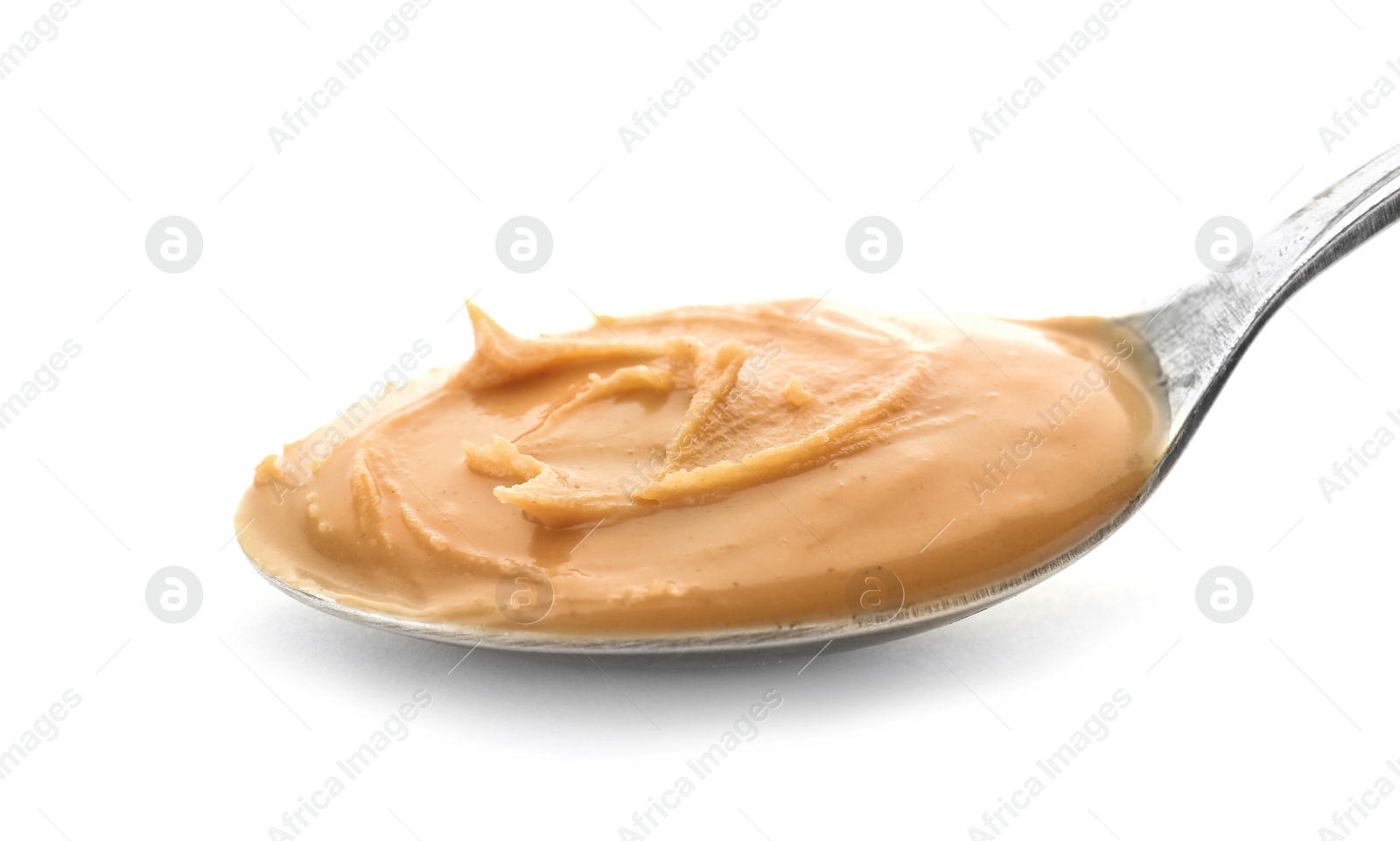 Photo of Creamy peanut butter in spoon on white background