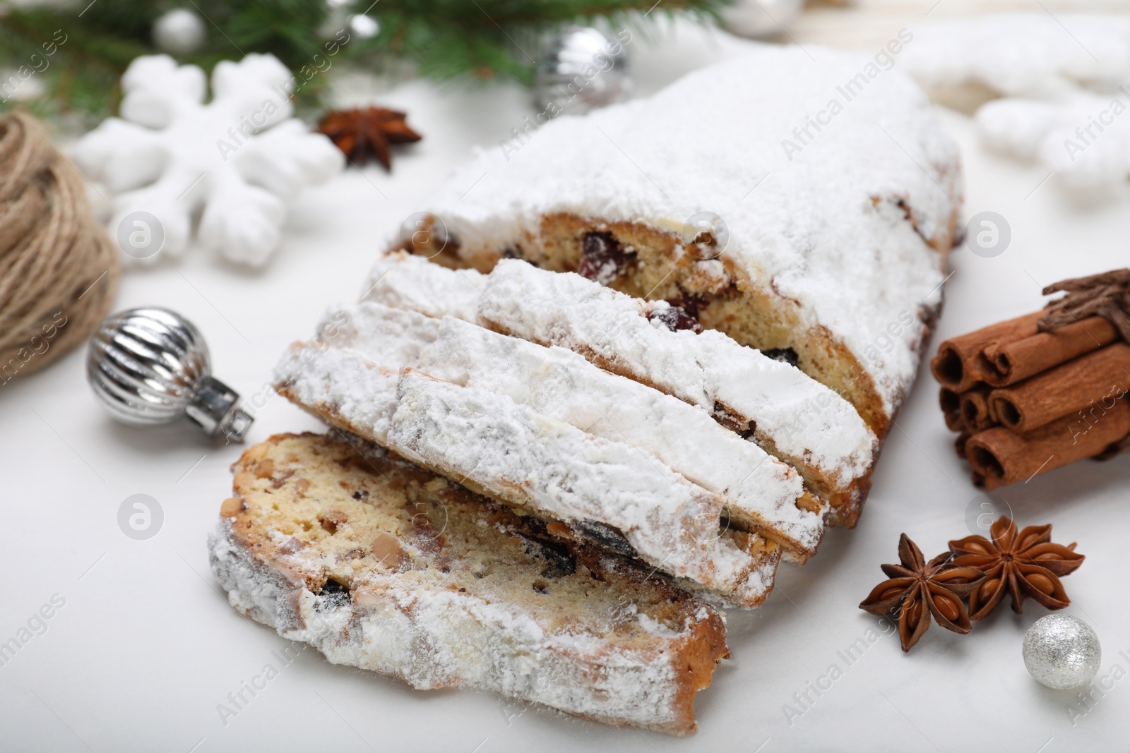 Photo of Traditional Christmas Stollen with icing sugar on white board, closeup