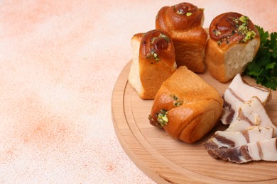 Photo of Delicious pampushky (buns with garlic), salo and parsley on color textured table. Space for text