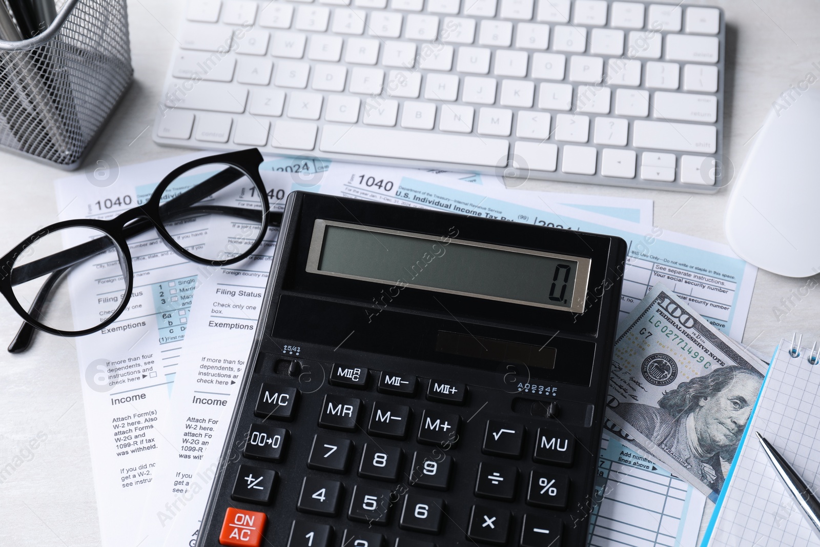 Photo of Tax accounting. Calculator, documents, keyboard, stationery and glasses on light grey table, above view