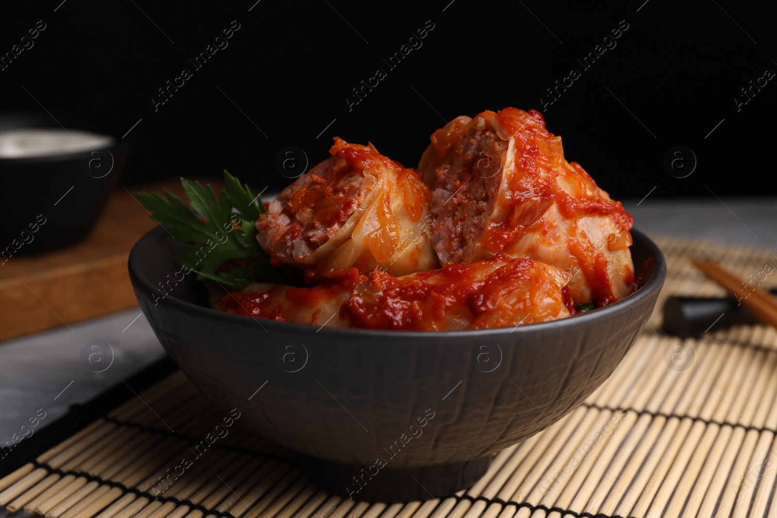 Photo of Delicious stuffed cabbage rolls cooked with homemade tomato sauce on table, closeup