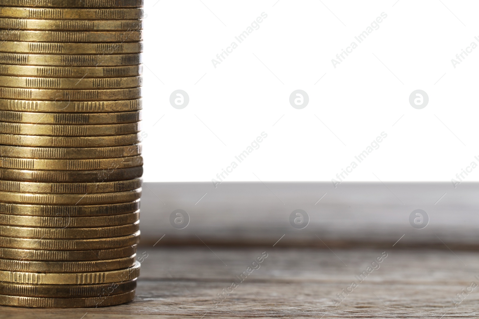 Photo of Stack of golden coins on wooden table, space for text